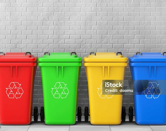 Multicoloured Garbage Trash Bins in front of brick wall. 3d Rendering